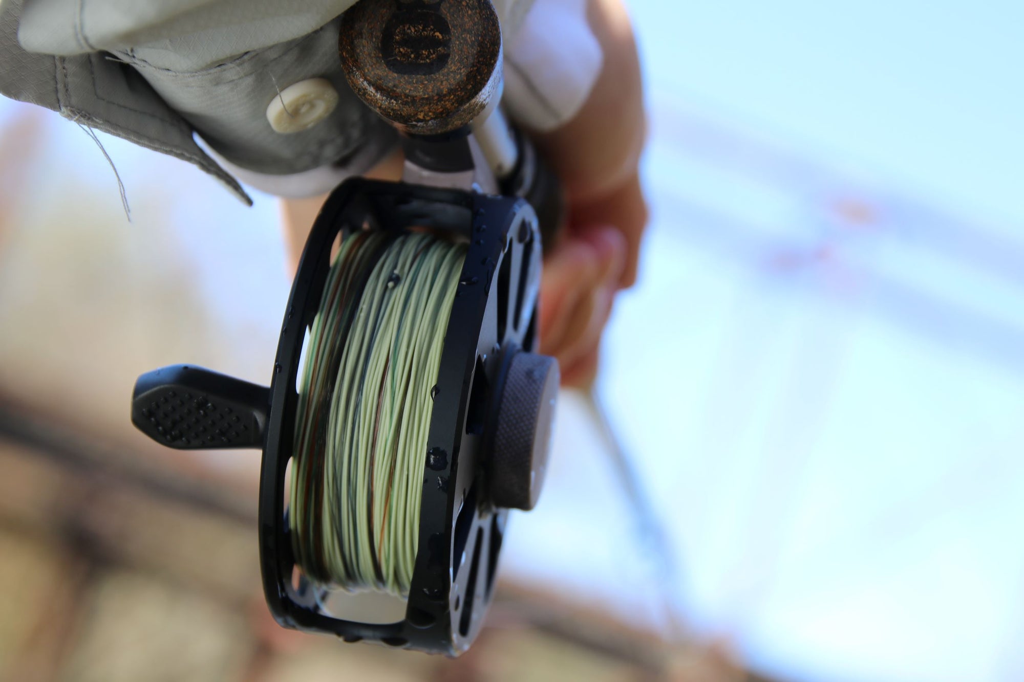 Bottom shot of someone holding onto a fly fishing pole and it is lined with Euro Nymph Braid Core.
