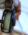 Bottom shot of someone holding onto a fly fishing pole and it is lined with Euro Nymph Braid Core.