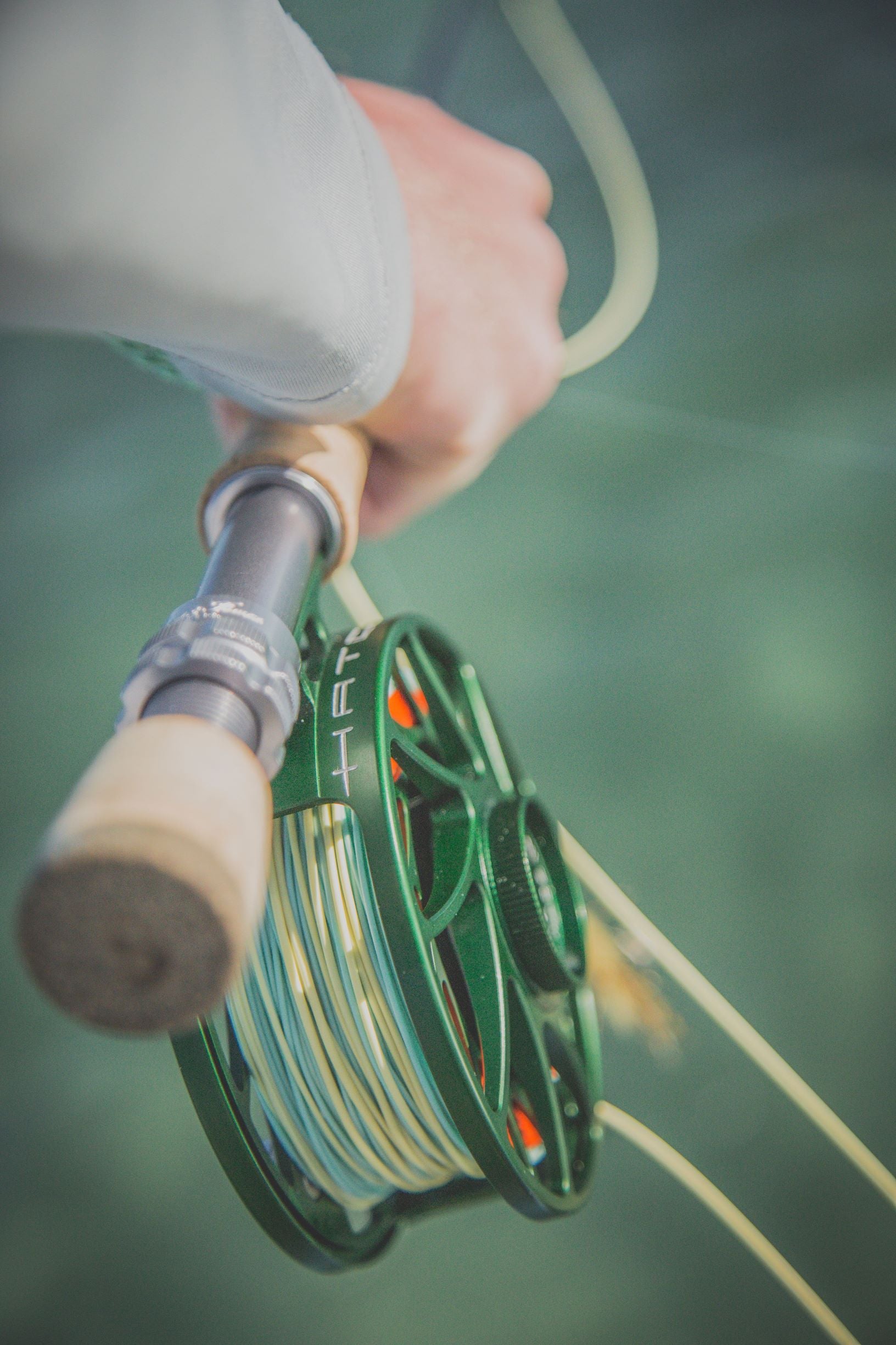 Closeup shot of someone holding onto their fly rod.