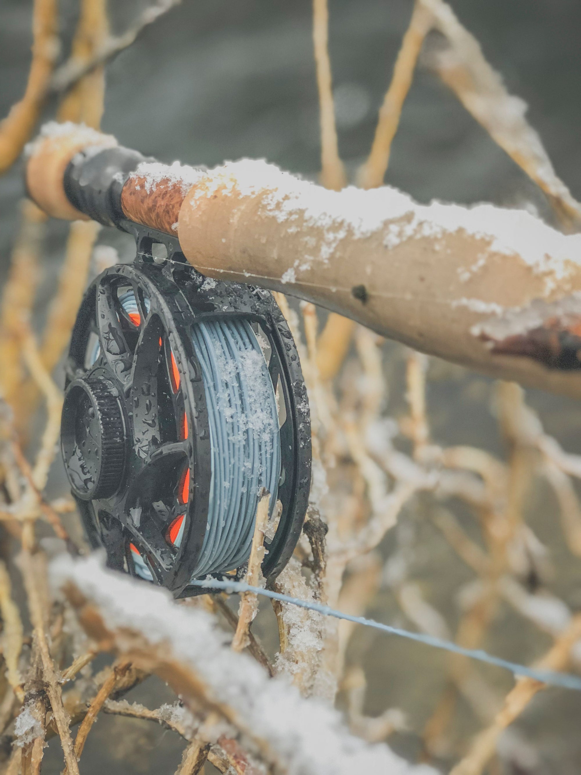 Closeup shot of the end of a fly rod lightly covered in snow.