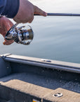 Closeup of someone's hands reeling in their fishing pole. 